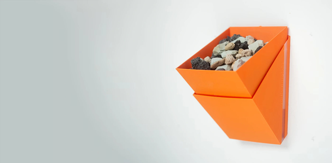 Orangefarbener Wandtopf mit mineralischem Substrat